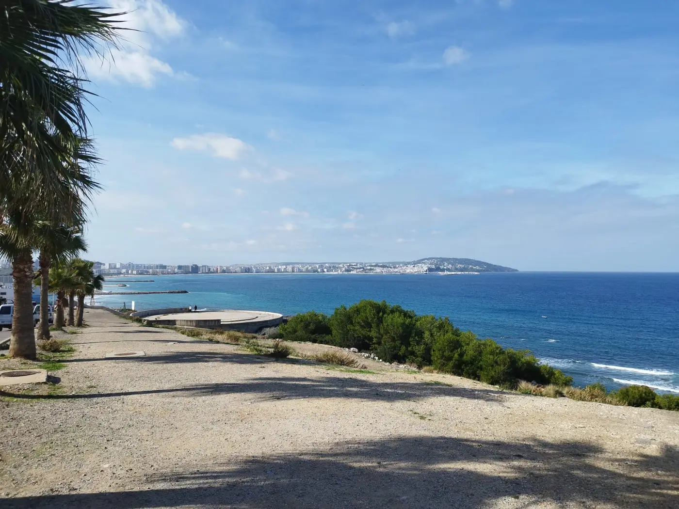 La baie de Tanger sous un ciel bleu, avec la corniche, les immeubles du front de mer et la médina au fond