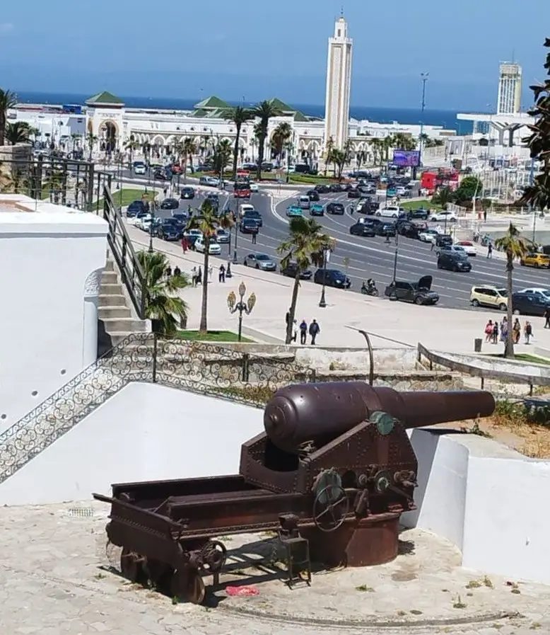Un ancien canon sur une terrasse de la médina de Tanger, avec le port, une mosquée et la mer en arrière-plan